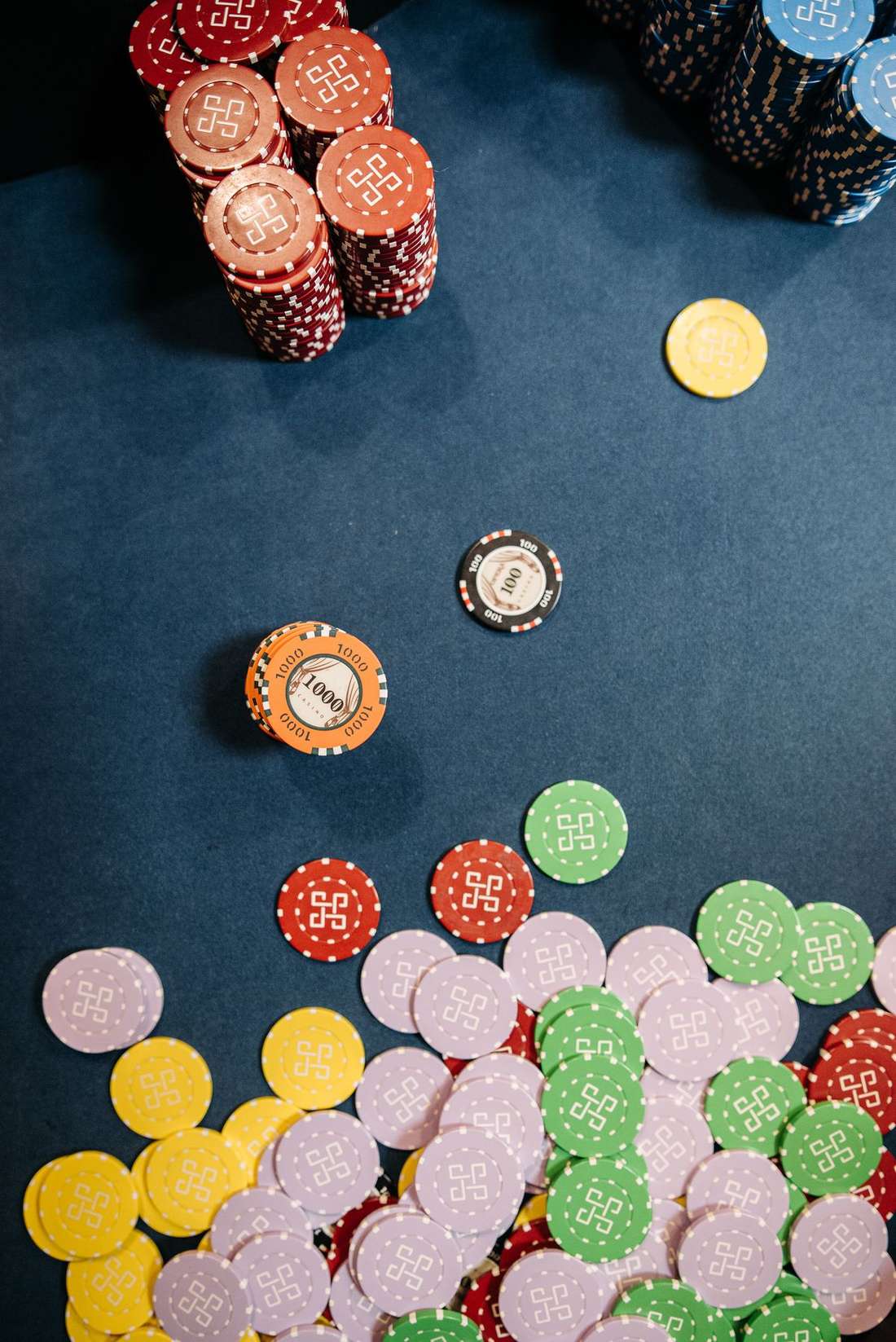 Keping poker berwarna bertumpuk di dekat kartu terbuka