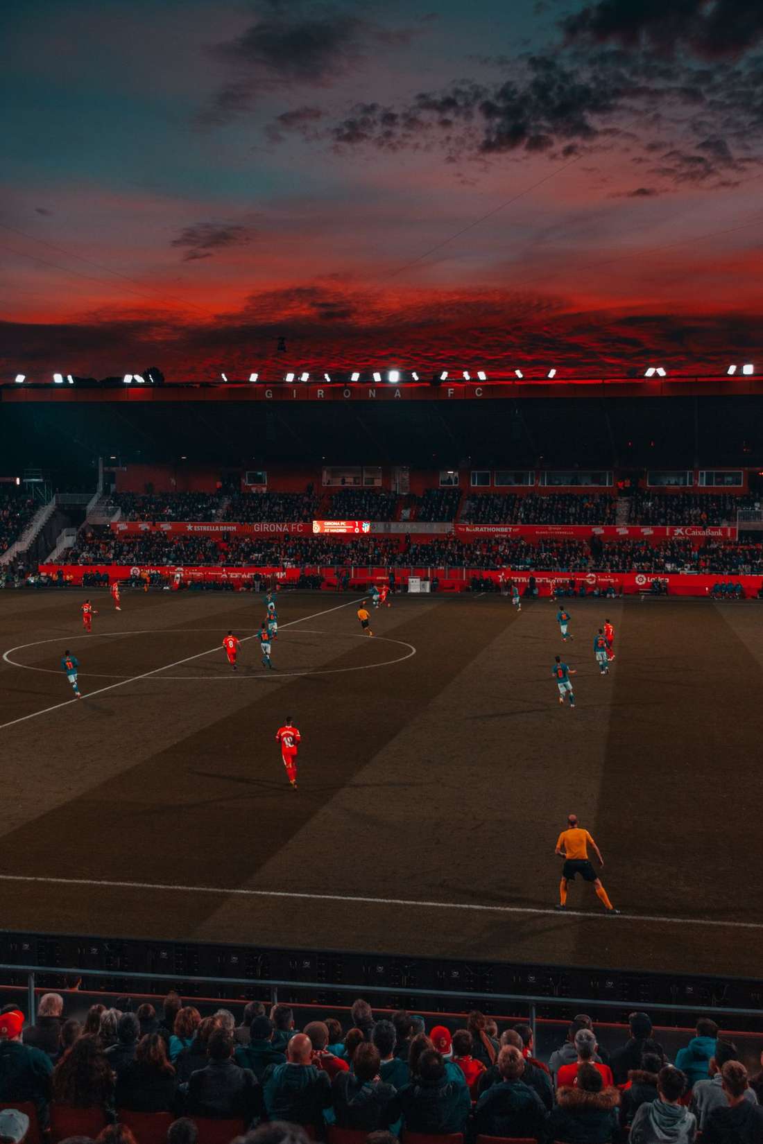 Stadion sepak bola dengan lampu sorot menyala sebelum pertandingan
